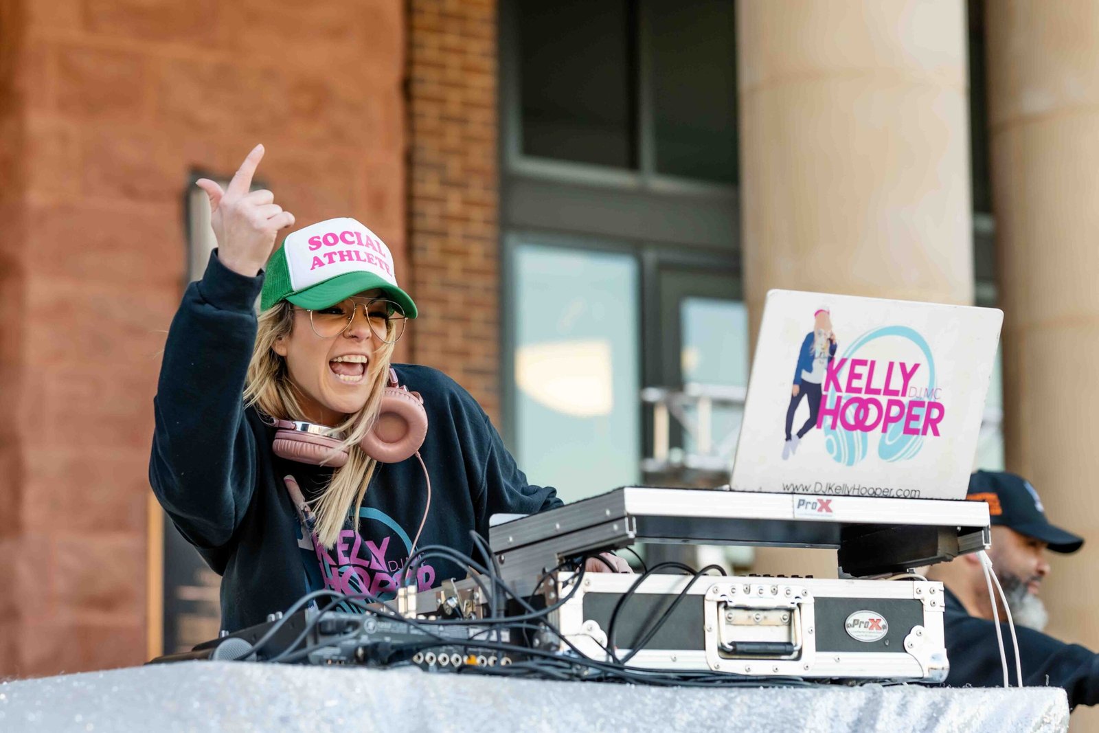 Local DJ elly Hooper standing at her equipment on a table outside city hall in Roanoke, Texas